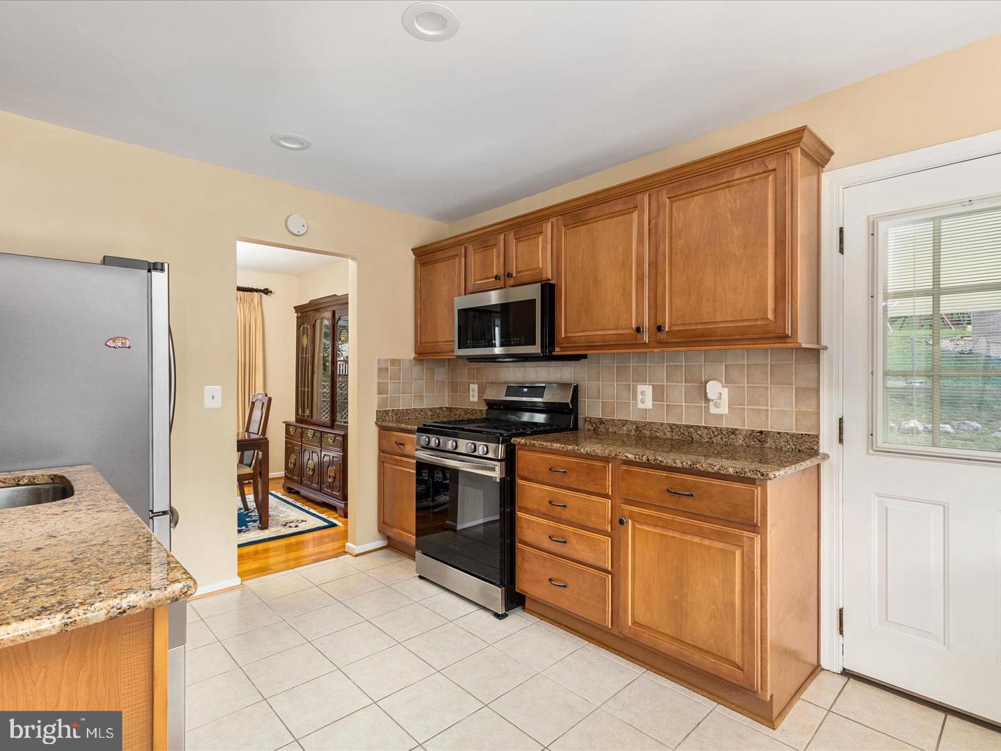 6434 Rives Court Springfield, VA 22150 - Photo 8 of 37 a kitchen with stainless steel appliances granite countertop a stove top oven a sink dishwasher and a refrigerator with wooden cabinets