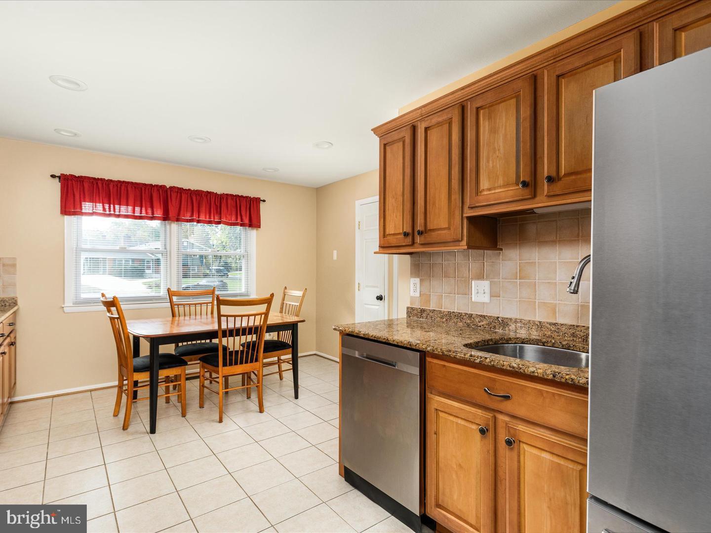 6434 Rives Court Springfield, VA 22150 - Photo 10 of 37 a kitchen with granite countertop a stove a sink dishwasher and a microwave with wooden cabinets
