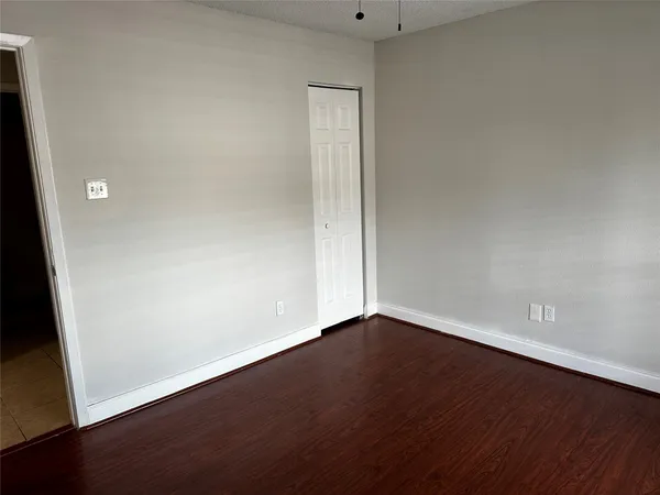 an empty room with wooden floor and closet