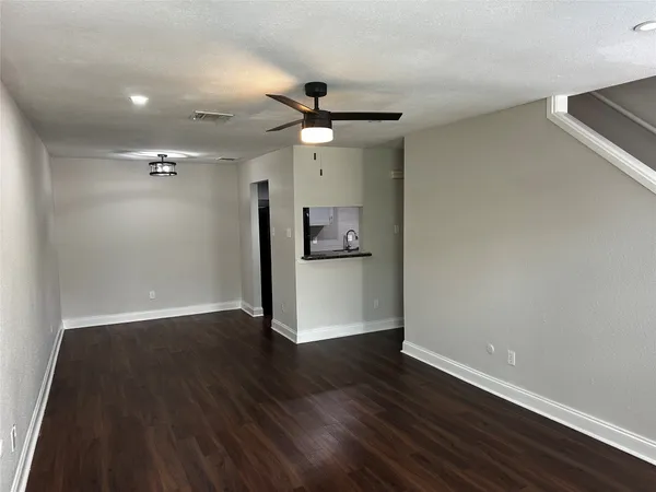 a view of a kitchen with wooden floor a ceiling fan and wooden floor