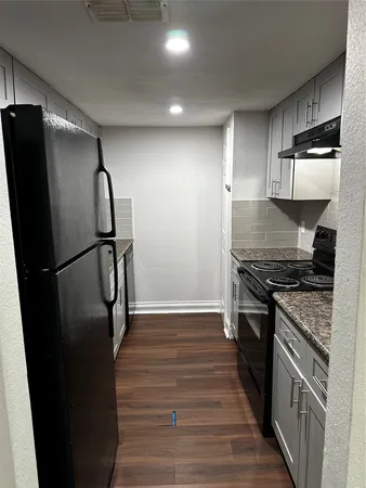 a kitchen with stainless steel appliances granite countertop a refrigerator and a stove