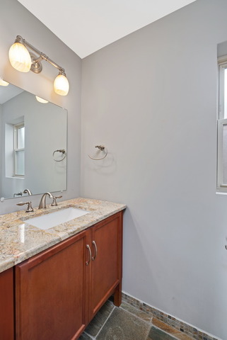 8013 West Irving Park Road Chicago, IL 60634 - Photo 12 of 25 a bathroom with a granite countertop sink and a mirror