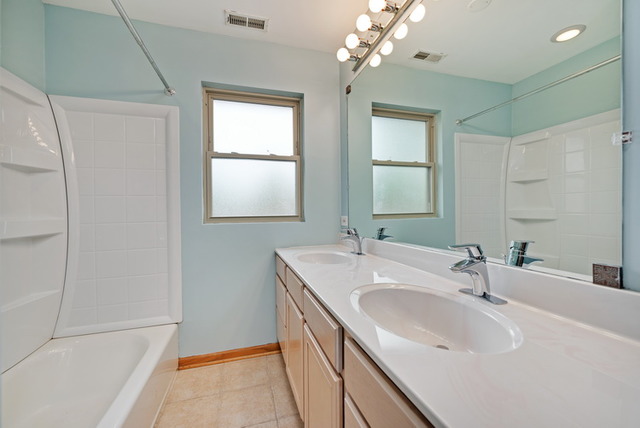 8013 West Irving Park Road Chicago, IL 60634 - Photo 17 of 25 a bathroom with a sink double vanity and a mirror