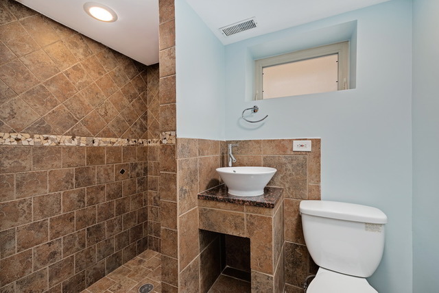 8013 West Irving Park Road Chicago, IL 60634 - Photo 22 of 25 a bathroom with a toilet a sink and mirror