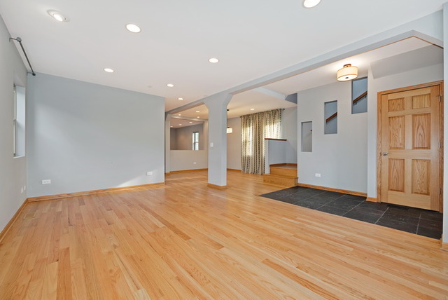 8013 West Irving Park Road Chicago, IL 60634 - Photo 5 of 25 a view of an empty room with wooden floor and a window