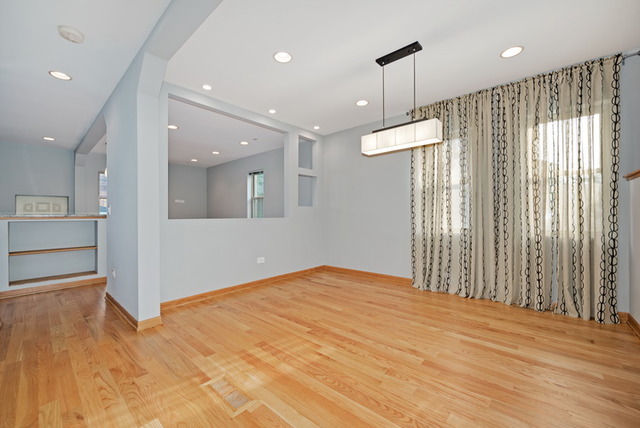 8013 West Irving Park Road Chicago, IL 60634 - Photo 6 of 25 a view of an empty room with wooden floor and a window