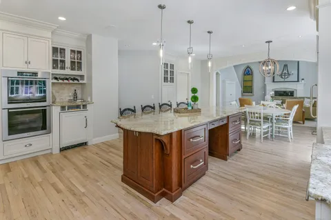 a kitchen with stainless steel appliances granite countertop a wooden cabinets a stove a sink and a wooden floors