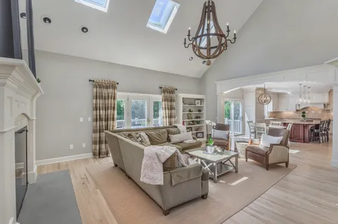 a living room with furniture a chandelier a rug and a window