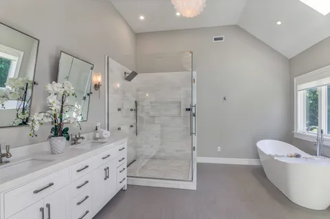 a bathroom with a granite countertop sink a toilet a mirror and shower