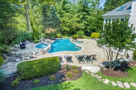an aerial view of a house with yard and swimming pool