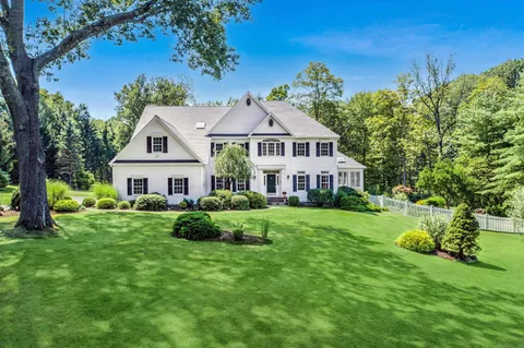a front view of a house with a yard and potted plants