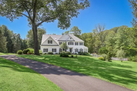 a house with green field in front of it