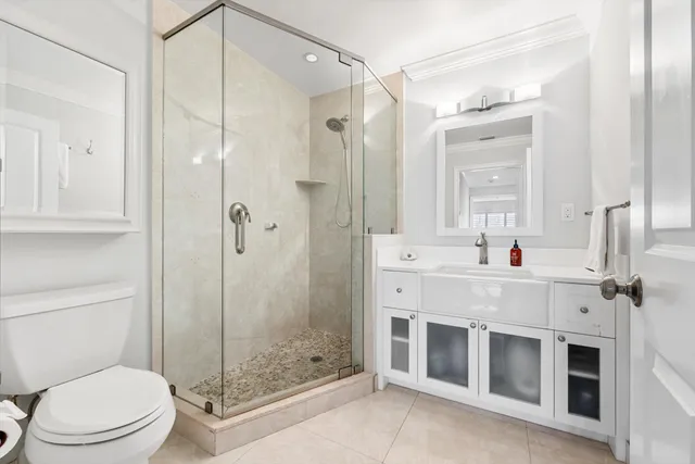 a bathroom with a sink a toilet and shower