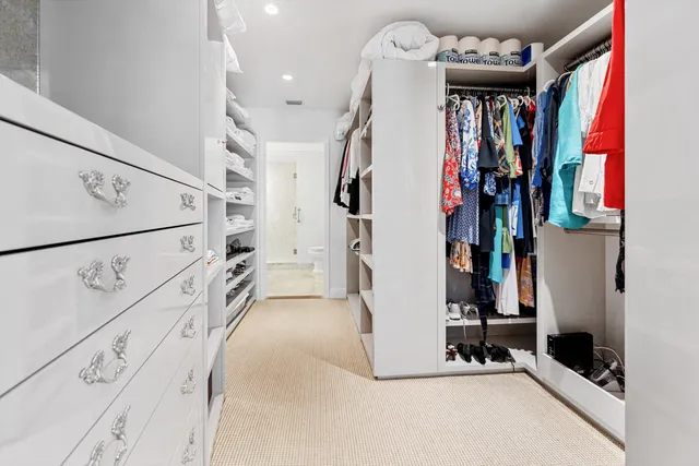 a view of walk in closet with clothes and shoes