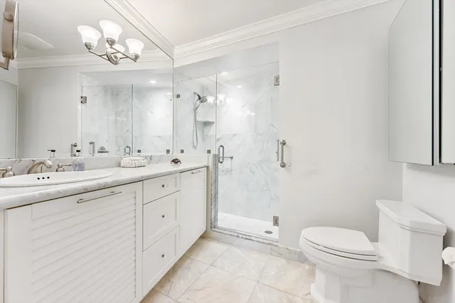 a spacious bathroom with a toilet sink double vanity and mirror
