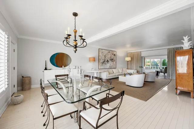 a view of dining room and livingroom with furniture wooden floor a chandelier