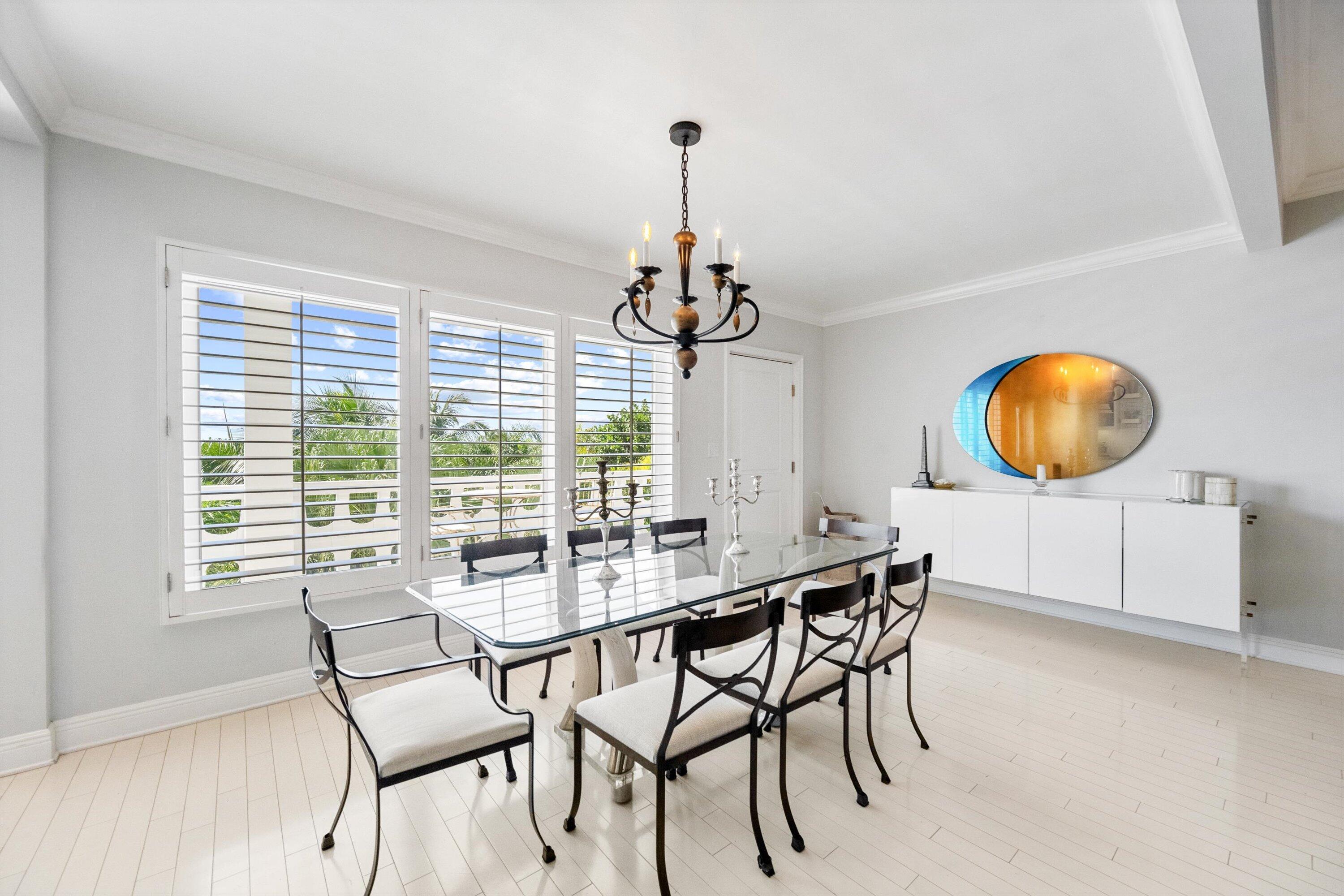 300 South Ocean Boulevard, Unit 4F Palm Beach, FL 33480 - Photo 4 of 19 a dining room with chandelier a wooden table and chairs