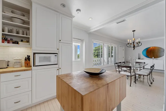 a kitchen with stainless steel appliances kitchen island granite countertop a sink a stove and a wooden floors