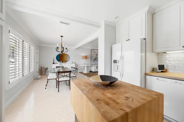 a kitchen with stainless steel appliances kitchen island granite countertop a sink a stove and a wooden floors