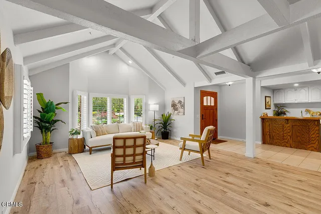 a dining room with furniture potted plants and wooden floor