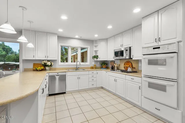 a kitchen with white cabinets and stainless steel appliances