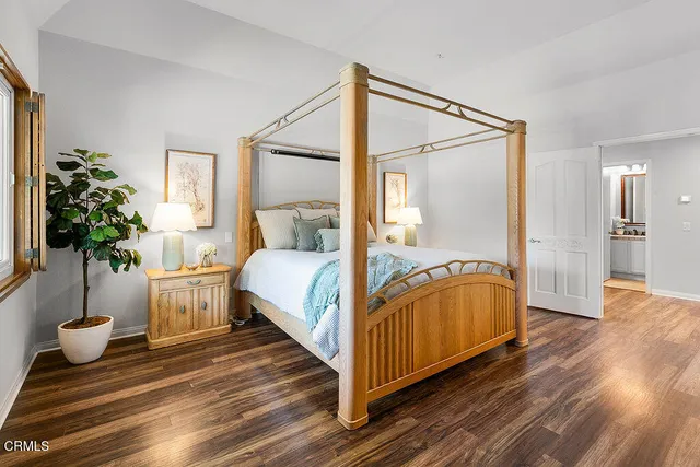 a spacious bedroom with a bed table and a window