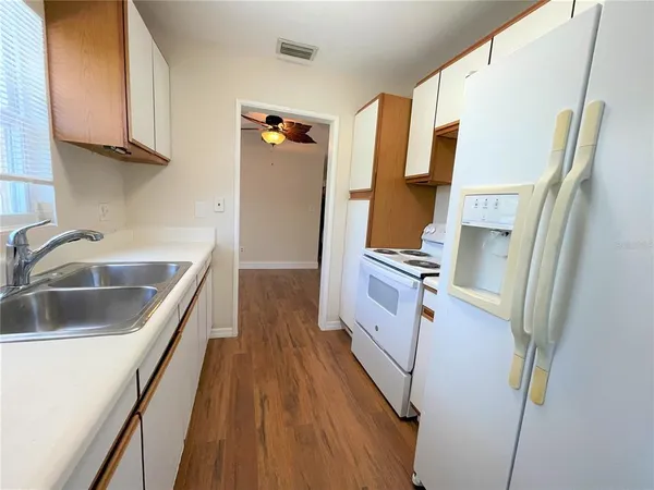 a kitchen with cabinets and wooden floor