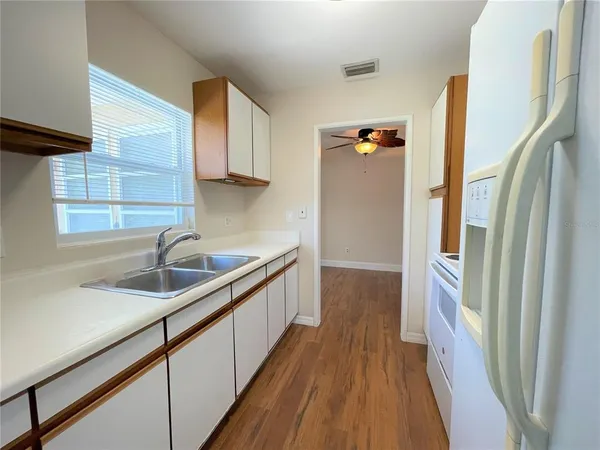 a kitchen with a sink a refrigerator and window