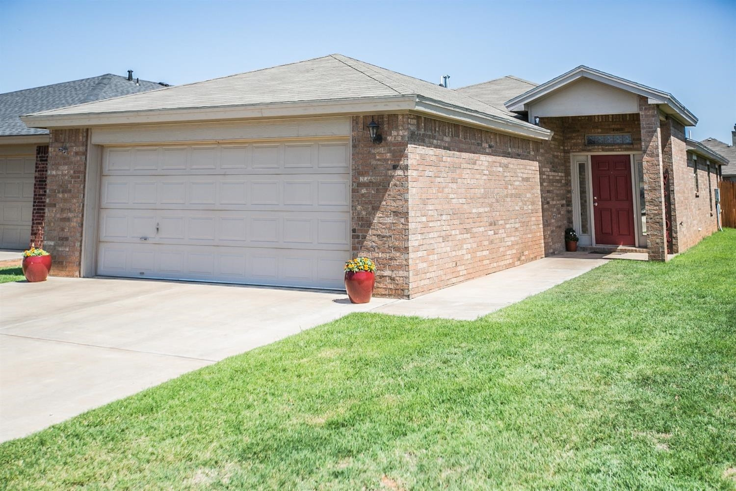 2204 100th Street Lubbock, TX 79423 - Photo 1 of 10 a front view of a house with a yard and garage