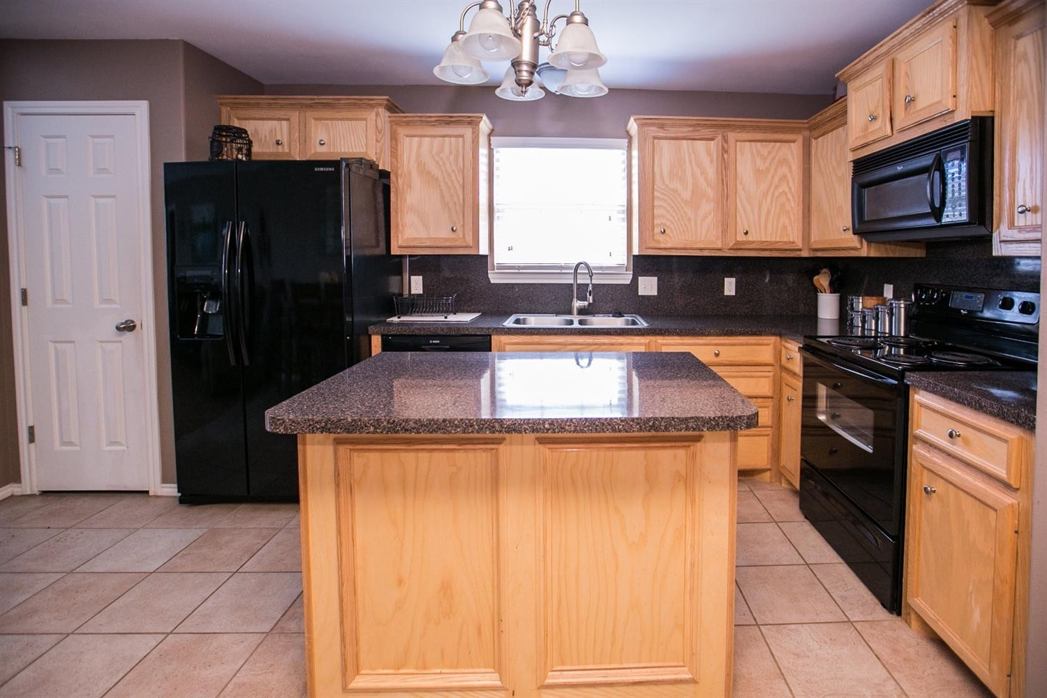 2204 100th Street Lubbock, TX 79423 - Photo 5 of 10 a kitchen with granite countertop a refrigerator a stove a sink and dishwasher