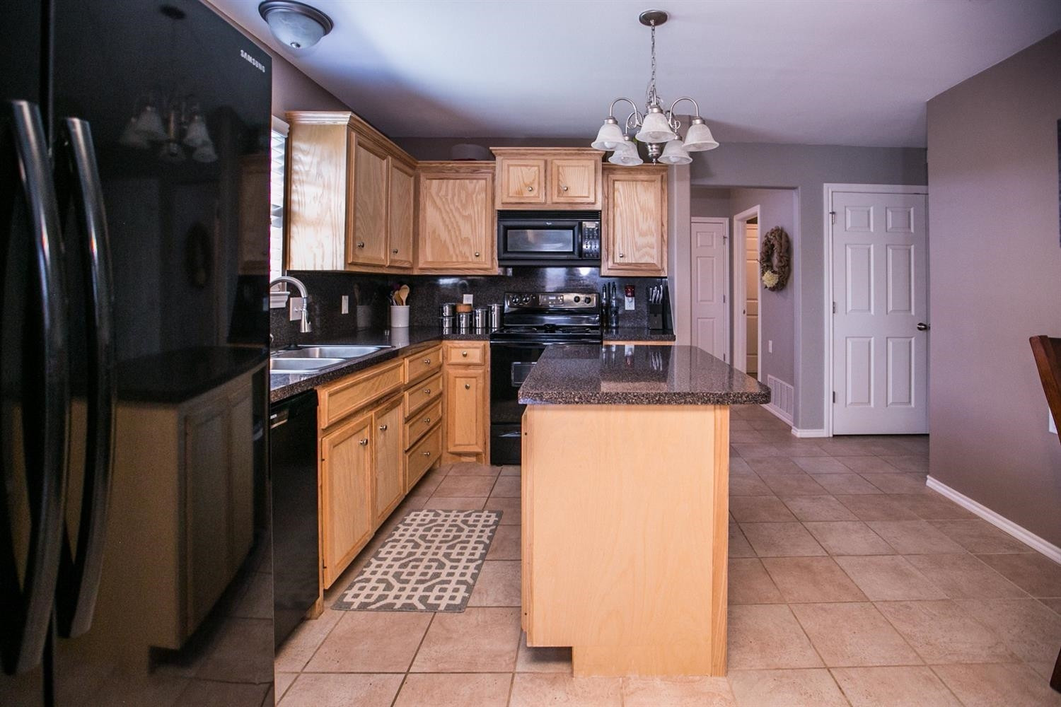 2204 100th Street Lubbock, TX 79423 - Photo 6 of 10 a kitchen with granite countertop a refrigerator a stove top oven a sink and dishwasher