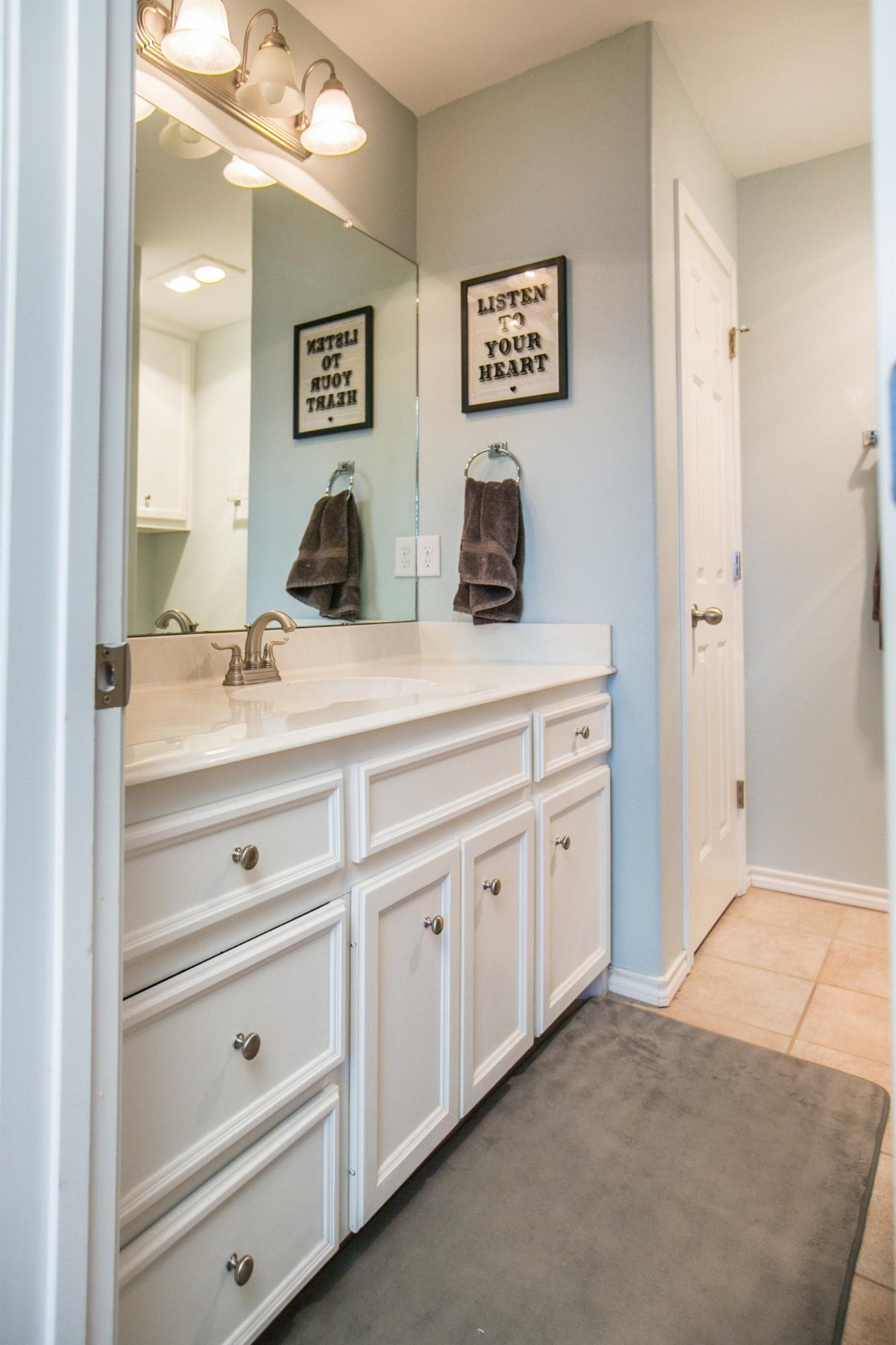 2204 100th Street Lubbock, TX 79423 - Photo 8 of 10 a spacious bathroom with double sink and a mirror