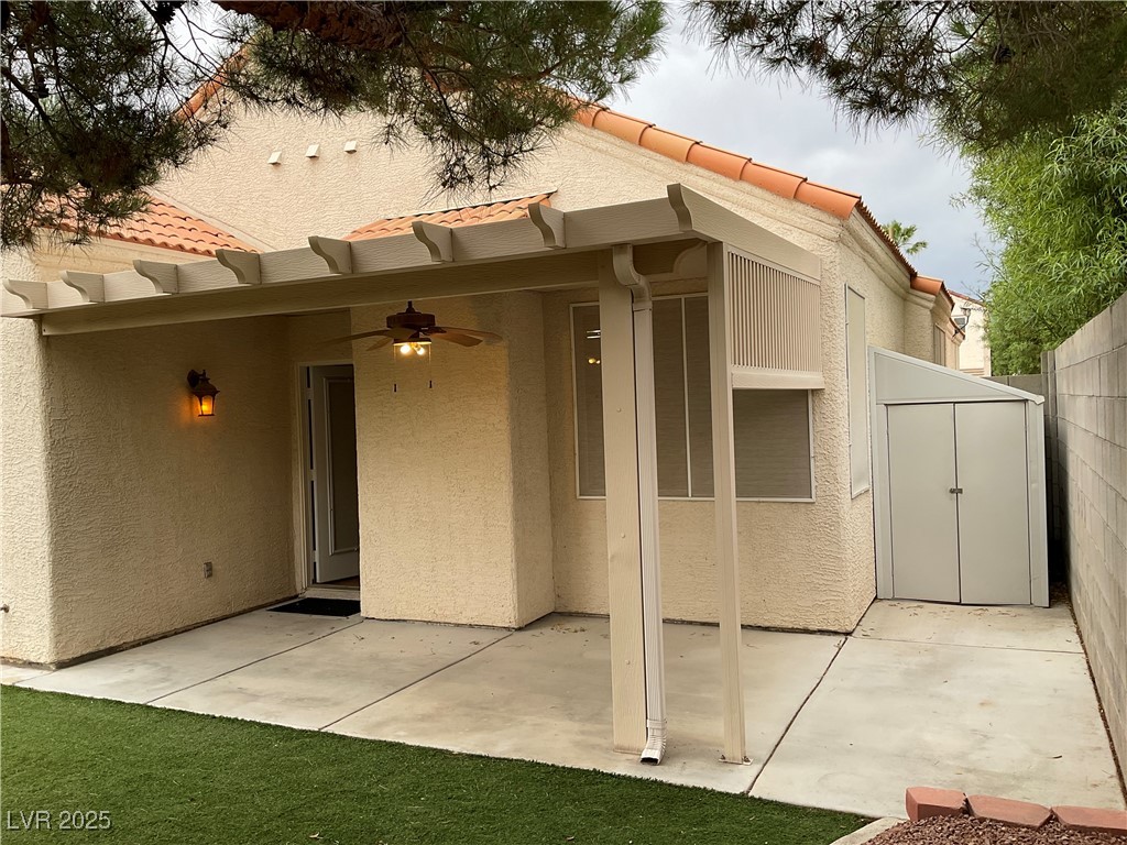 7620 Donald Nelson Avenue Las Vegas, NV 89131 - Photo 23 of 34 Rear view of house with stucco siding, ceiling fan, a patio, and a tiled roof