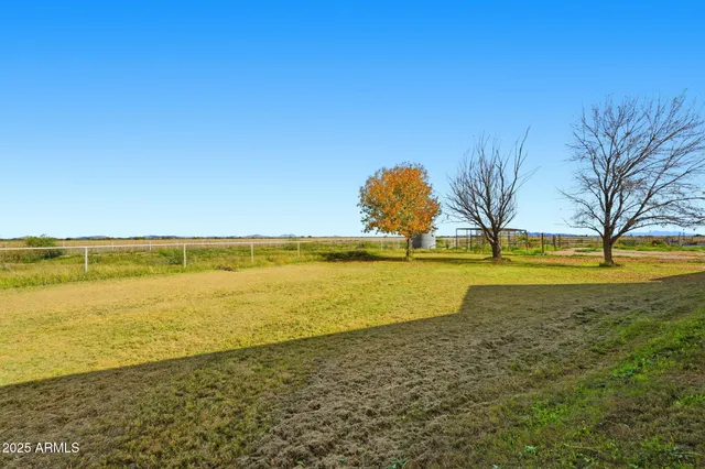 a view of a swimming pool with lawn chairs and ocean view