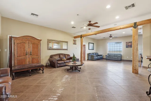a living room with furniture a table and kitchen view