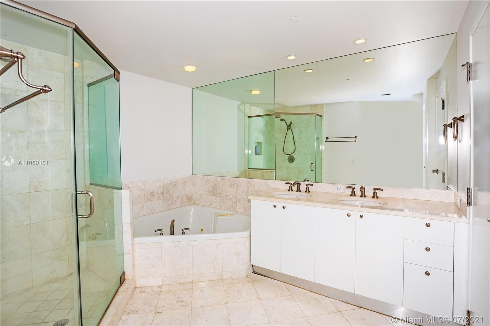 901 Brickell Key Boulevard, Unit 1406 Miami, FL 33131 - Photo 13 of 25 a bathroom with a bathtub sink and mirror