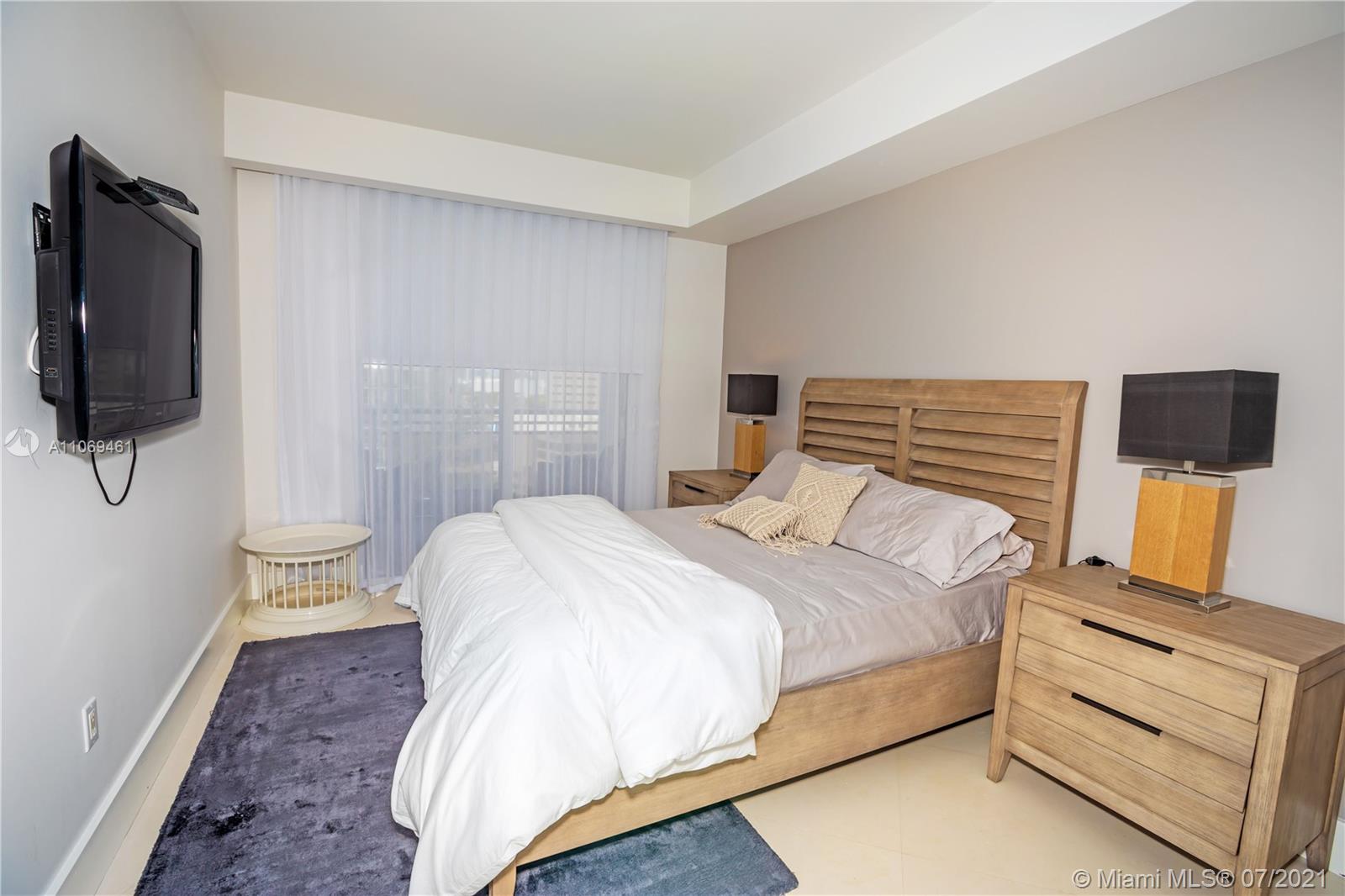 901 Brickell Key Boulevard, Unit 1406 Miami, FL 33131 - Photo 15 of 25 a bedroom with a bed and flat screen tv