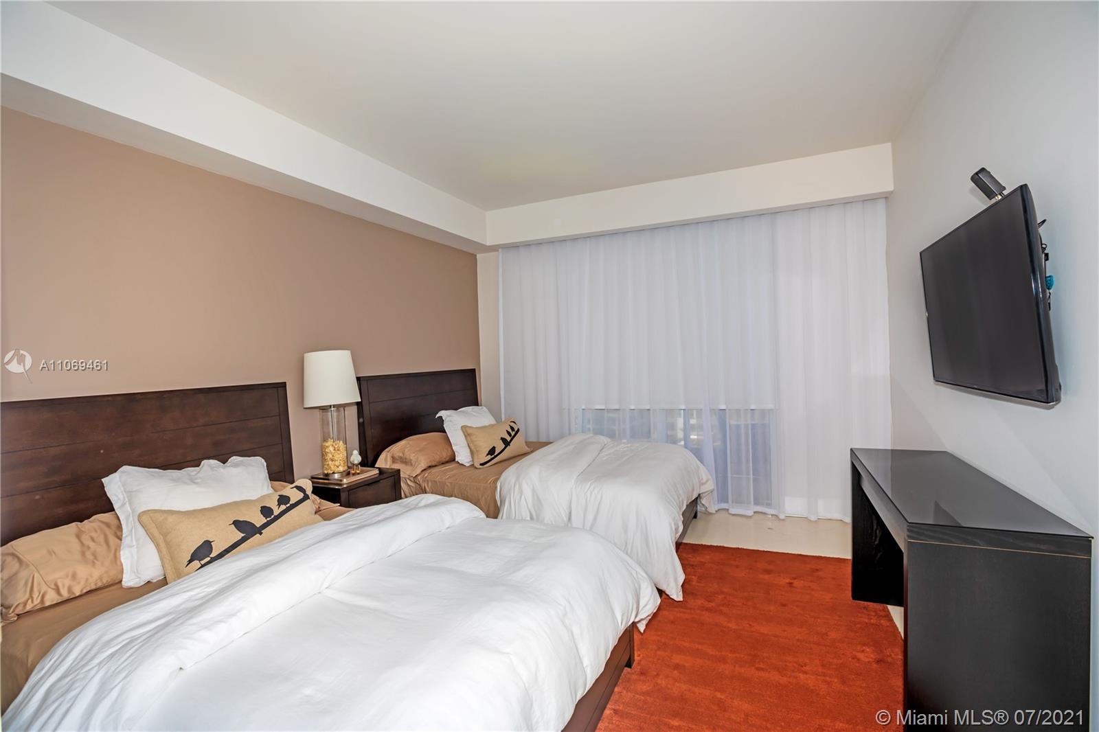 901 Brickell Key Boulevard, Unit 1406 Miami, FL 33131 - Photo 16 of 25 a bedroom with a bed and a flat screen tv