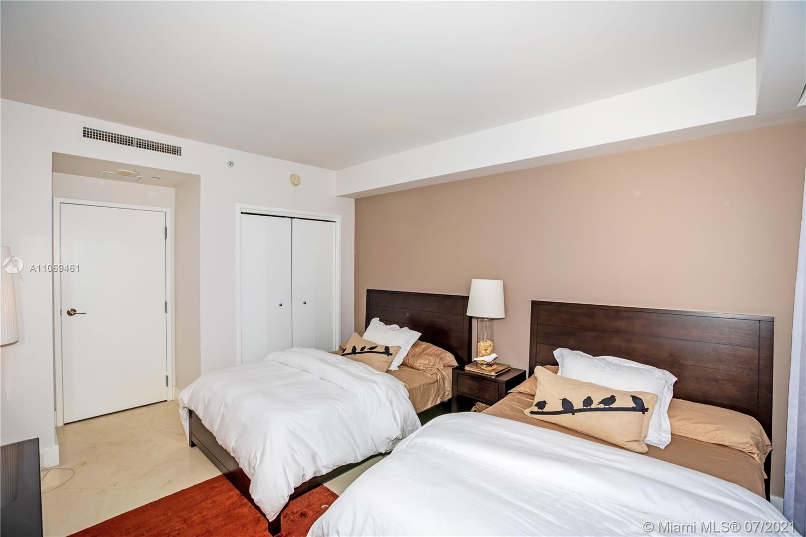 901 Brickell Key Boulevard, Unit 1406 Miami, FL 33131 - Photo 17 of 25 a bedroom with two beds and a night stand