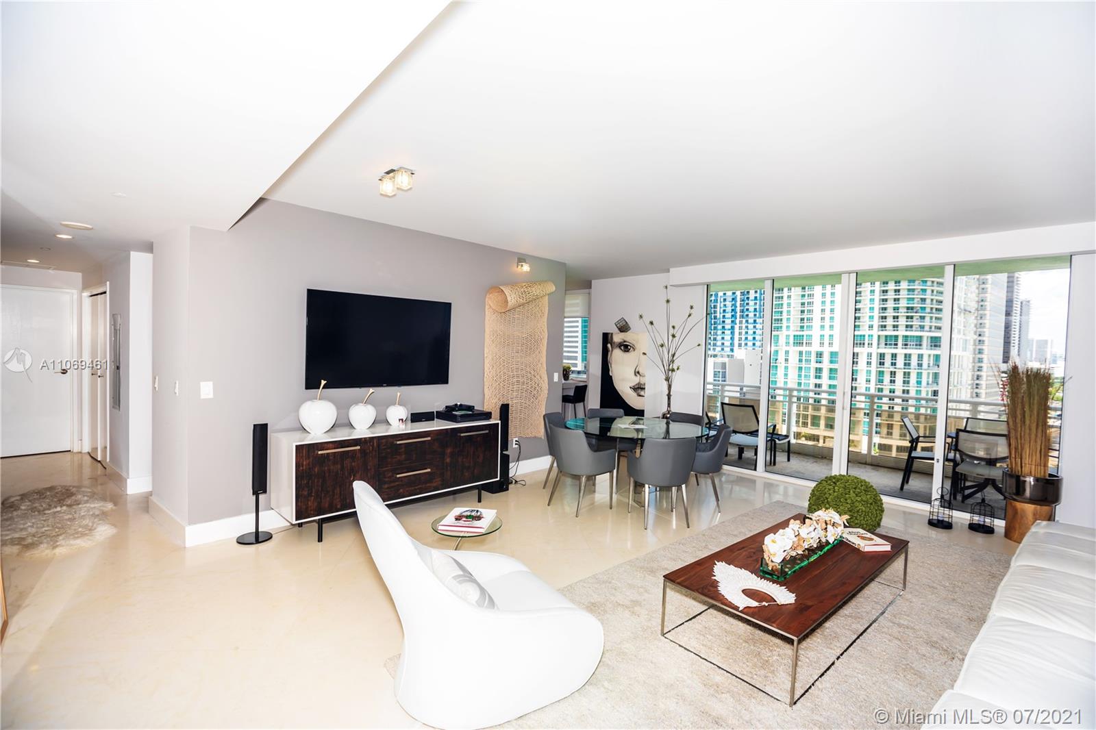 901 Brickell Key Boulevard, Unit 1406 Miami, FL 33131 - Photo 4 of 25 a living room with furniture and a flat screen tv