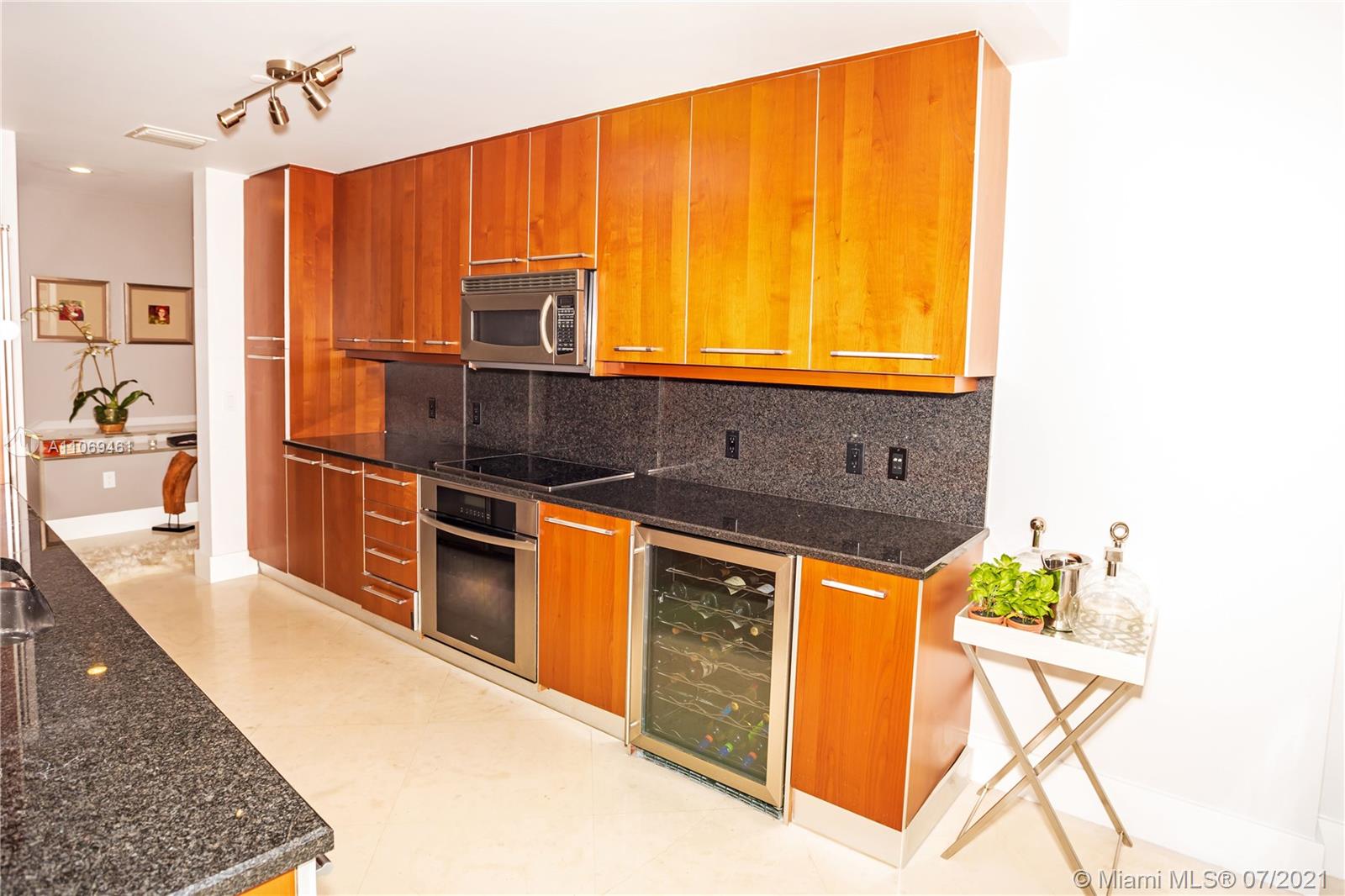 901 Brickell Key Boulevard, Unit 1406 Miami, FL 33131 - Photo 8 of 25 a kitchen with stainless steel appliances granite countertop a stove a sink and a microwave