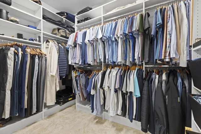 a view of walk in closet with clothes and shoes