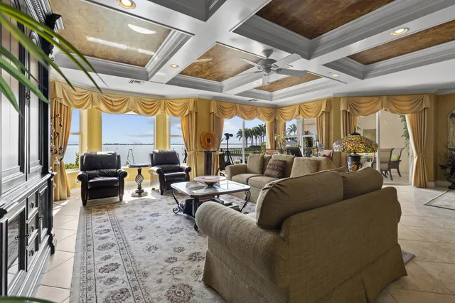 a living room with furniture fireplace and large windows