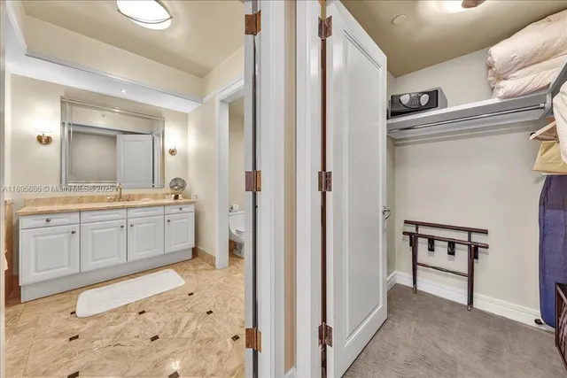 a bathroom with a granite countertop sink a toilet and a mirror