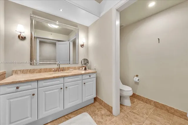 a spacious bathroom with a sink a toilet a mirror and bathtub