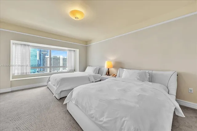 a bedroom with two beds and a lamp on the dresser