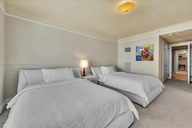 a large white bed sitting in a bedroom next to a window