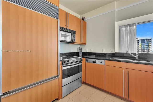a kitchen with granite countertop a refrigerator and a sink