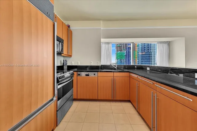 a kitchen with stainless steel appliances granite countertop a refrigerator and a sink