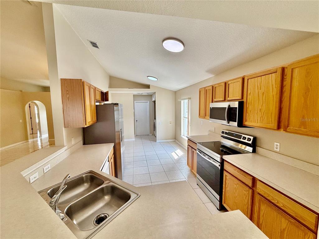 1346 Rolling River Road DeLand, FL 32720 - Photo 11 of 31 a kitchen with stainless steel appliances granite countertop a stove and a sink with granite countertops
